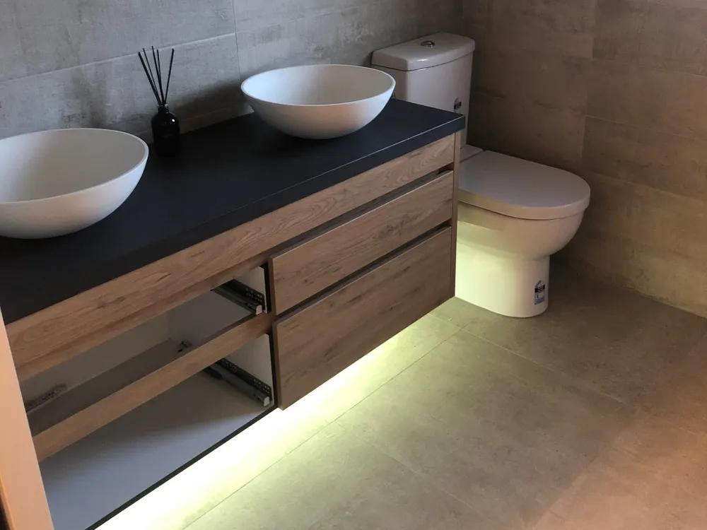 Bathroom vanity with double basins and warm LED strip lighting
