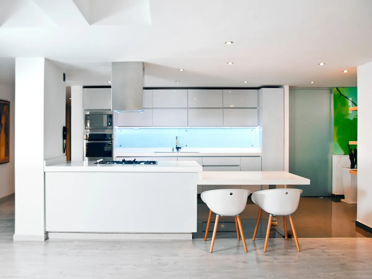 Renovated open-plan kitchen with island bench and downlights