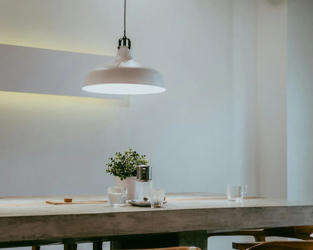 Warm pendant lighting over a dining table in a modern interior